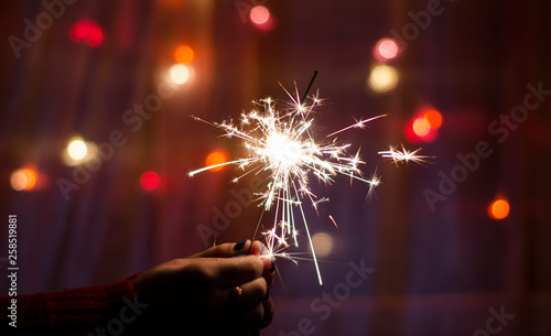 Person hold a sparkler stick in a hand. Festival sparklers. Happy New year. 