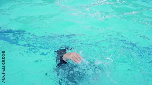 The boys are playing in the pool during the summer.. The boy is drowning