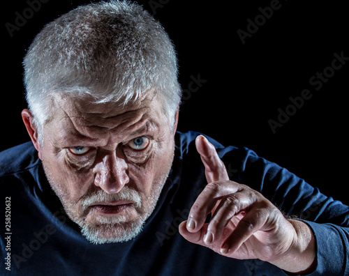 Portrait of a senior man threateningly raising his finger