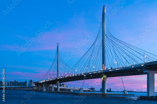 The bridge of circle highway road over Neva river near the mouth of it in the blue hour after the sunset. Night view on the buildings of Petersburg city and the Finish gulf © Майджи Владимир