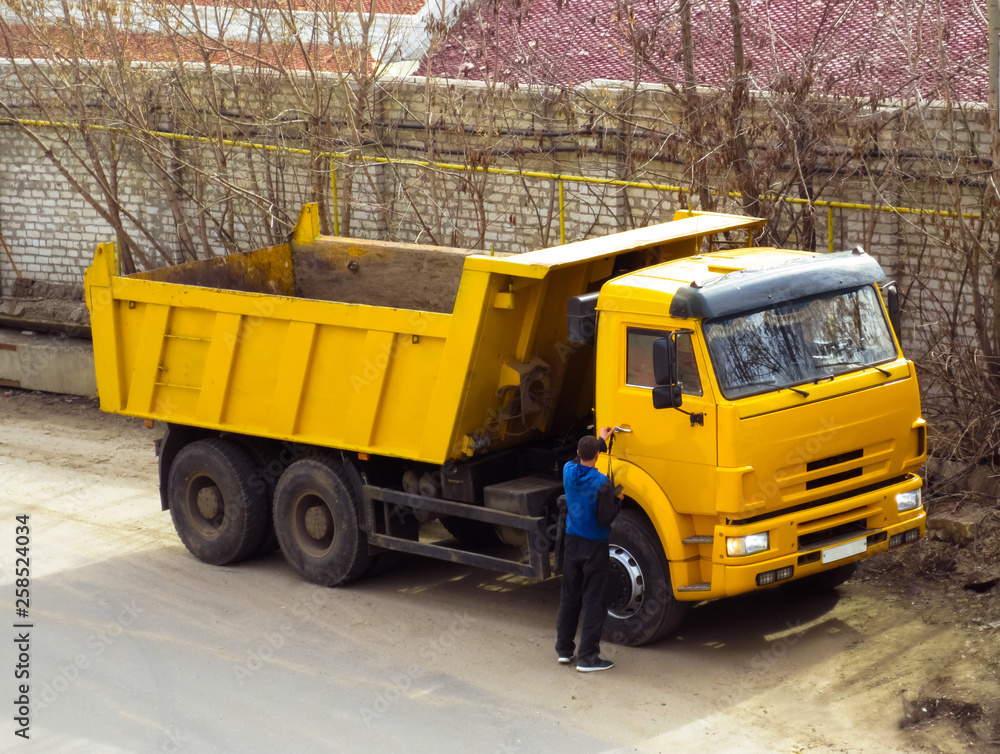 The driver next to the industrial yellow truck