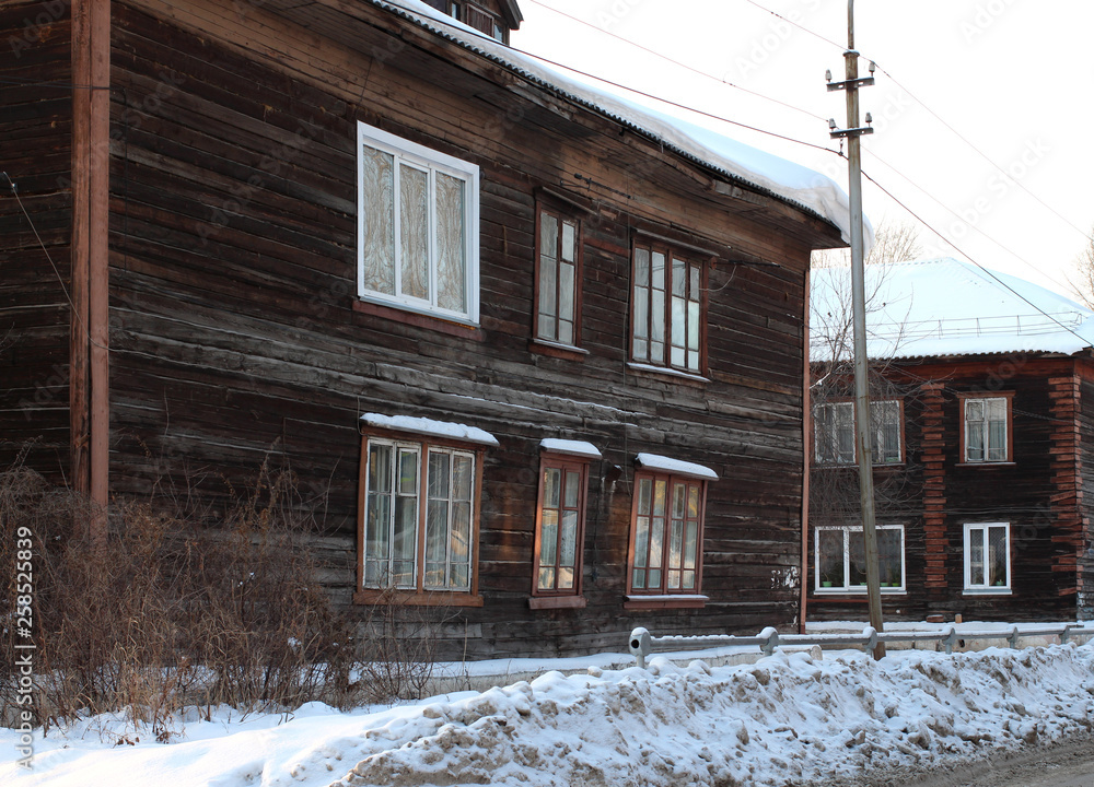 Old wooden apartment building with a beautiful porch of boards in winter in Siberia Old wooden apartment building with a beautiful porch of boards in winter in Siberia