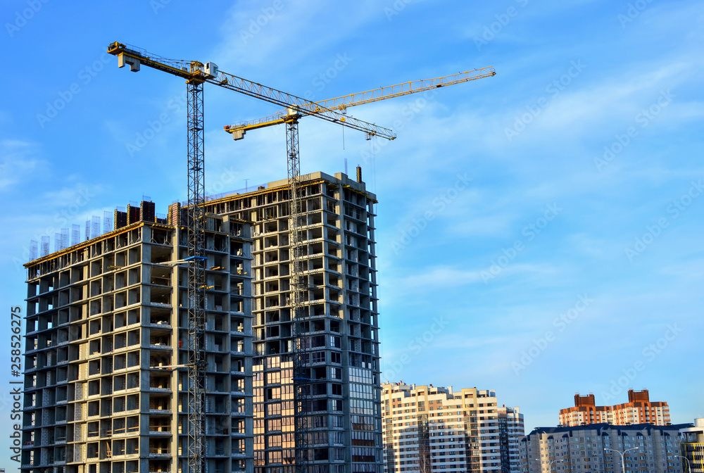 Large construction site with cranes on the blue sky background.