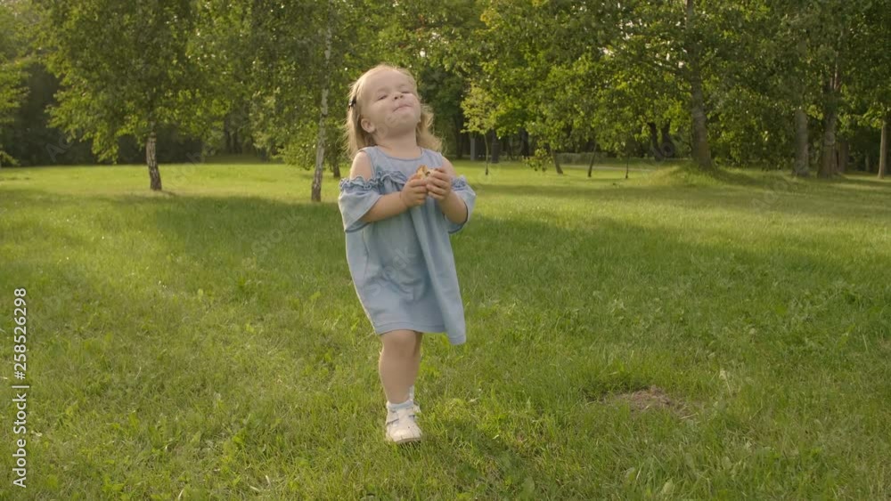 Baby girl running through the grass and rushes into mother hands in garden in sunset sunlight. Slow motion. Happy smiling baby girl. Baby girl running through the grass and rushes into mother hands in garden in sunset sunlight. Slow motion. Happy smiling baby girl.