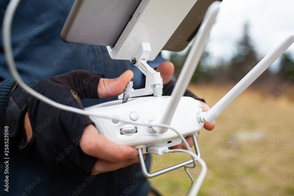 Male tourist exploring new places. Handsome bearded man on nature with fuel. Using drone photographs and shoots nature