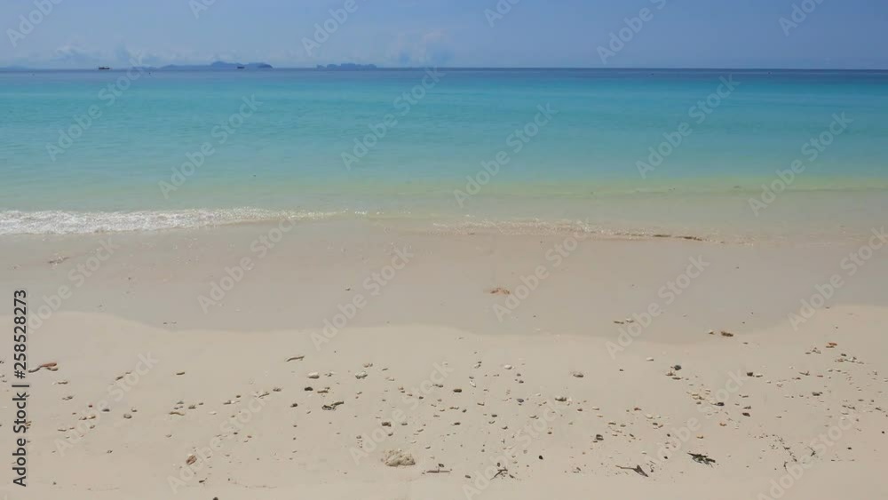 White sand beach blue lagoon and sky background . Soft waves in the beach with a clear water. Tropical beach. White sand beach blue lagoon and sky background . Soft waves in the beach with a clear water. Tropical beach.