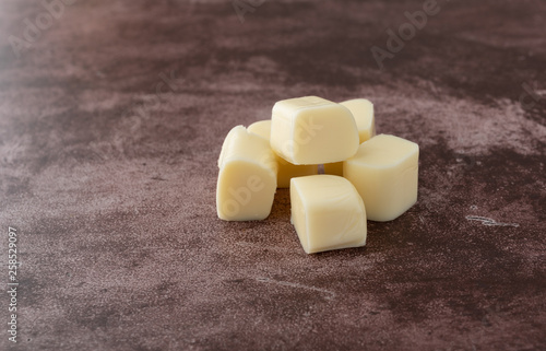 Small pile of mozzarella string cheese pieces on a red background photo