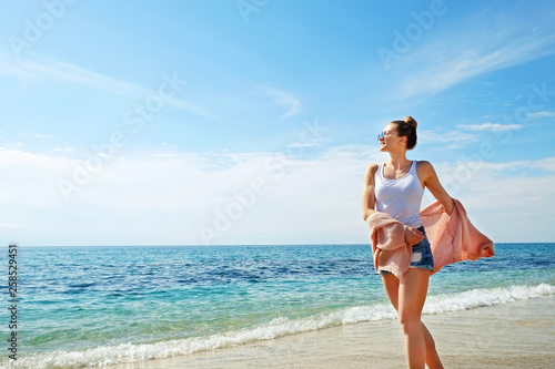 Portrait of young beautiful woman in tropical destination island beach with the ocean background. Joy of summer holidays concept. Close up, copy space © Evrymmnt