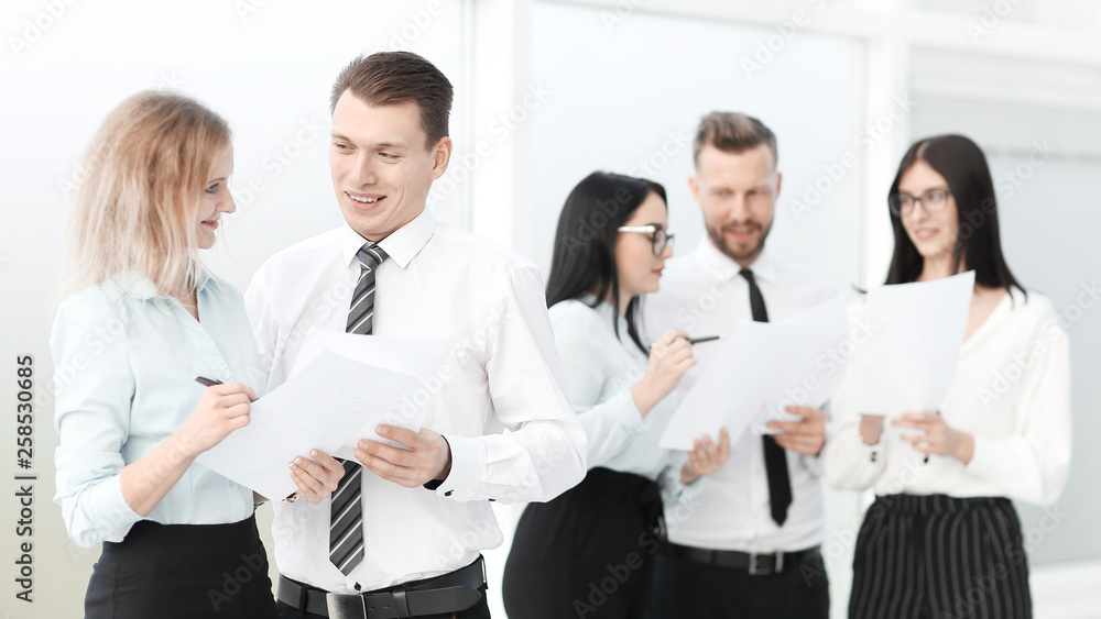 group of employees standing in the office lobby before the meeting group of employees standing in the office lobby before the meeting