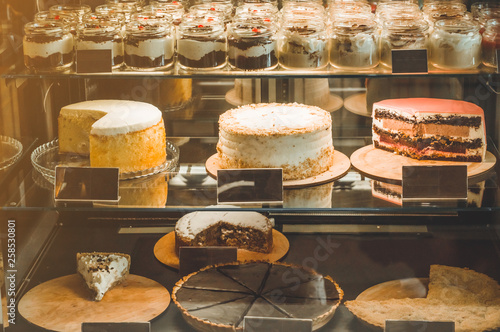 Many delicious cakes in the window of a cozy cafe. Tasty sweets.