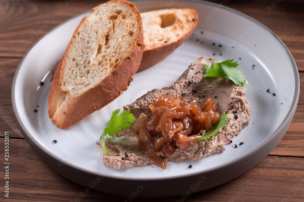 Fresh homemade chicken liver pate on bread over rustic background Fresh homemade chicken liver pate on bread over rustic background