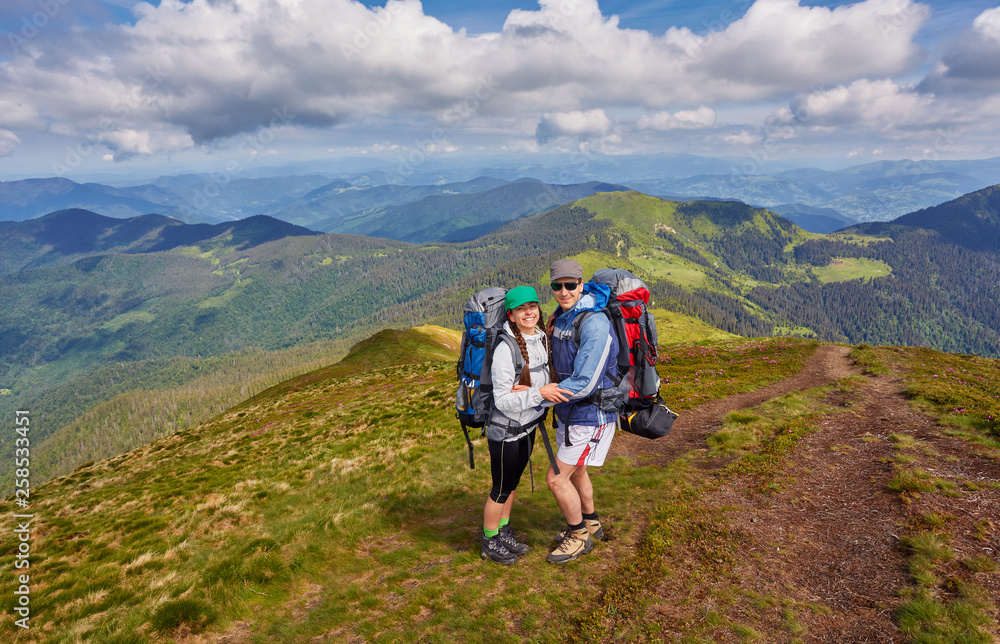 couple of hikers with backpacks enjoying panoramic view