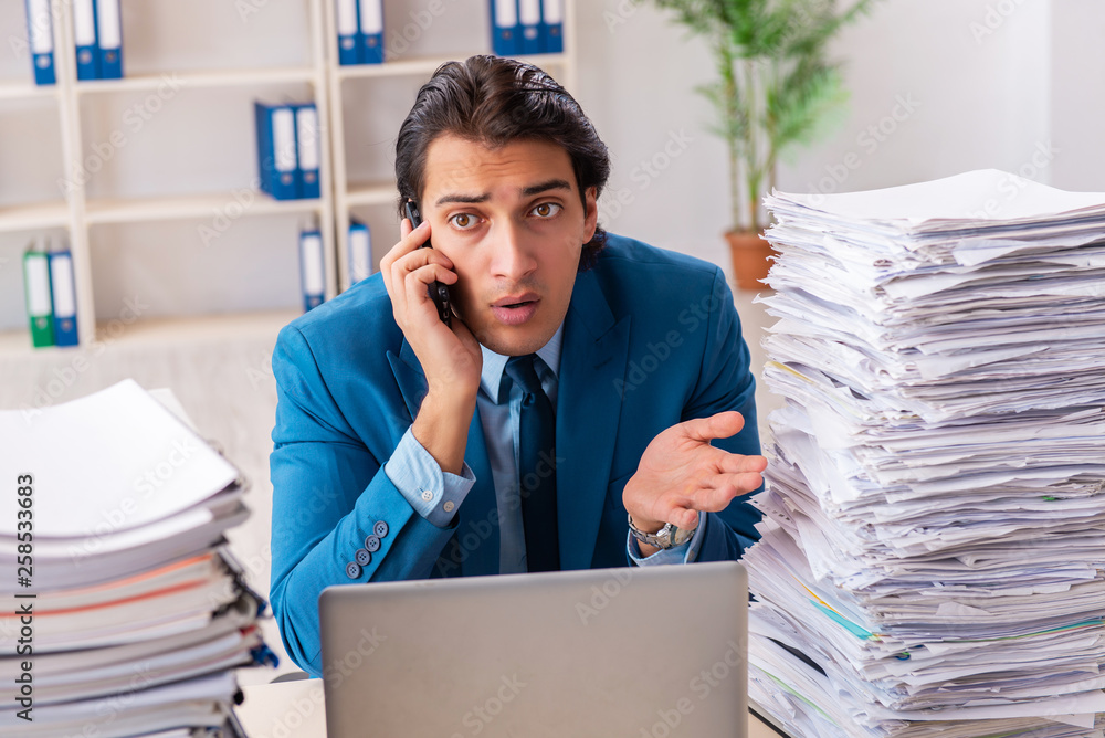 Naklejka premium Young handsome businessman unhappy with excessive work 
