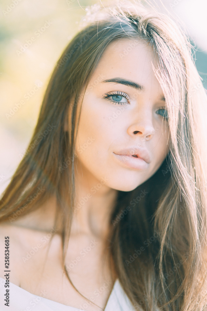 Fototapeta premium Dziewczyna w sukience buduar na jeziorze, stojąc i uśmiechając się. Jedność z naturą, poranna panna młoda w Rosji. Piękne oczy i wygląd modelu