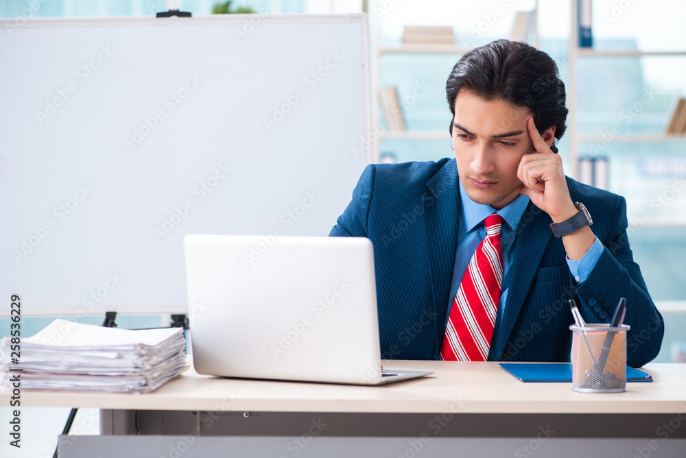 Young handsome businessman in front of whiteboard 