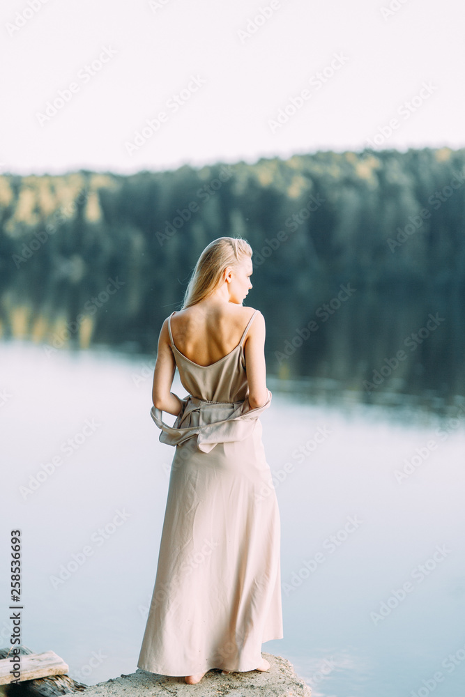 Girl in boudoir dress by the lake at sunset. Fees bride's on nature, harmony. Beautiful model, Russian girl with long hair Girl in boudoir dress by the lake at sunset. Fees bride's on nature, harmony. Beautiful model, Russian girl with long hair