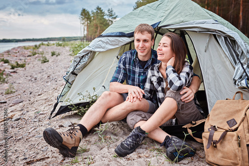 Couple camping. Young people sitting in tent