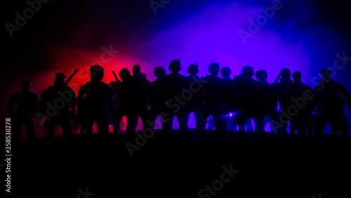 Anti-riot police give signal to be ready. Government power concept. Police in action. Smoke on a dark background with lights. Blue red flashing sirens.