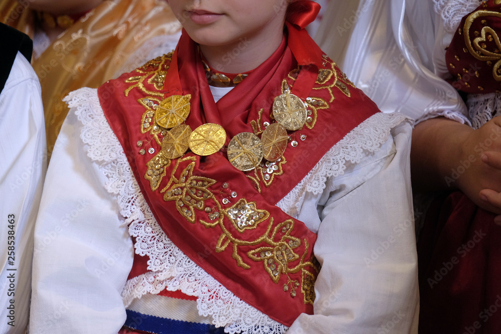 Girl dressed in traditional regional folk costumes in the church at the Mass on Thanksgiving day in Stitar, Croatia
