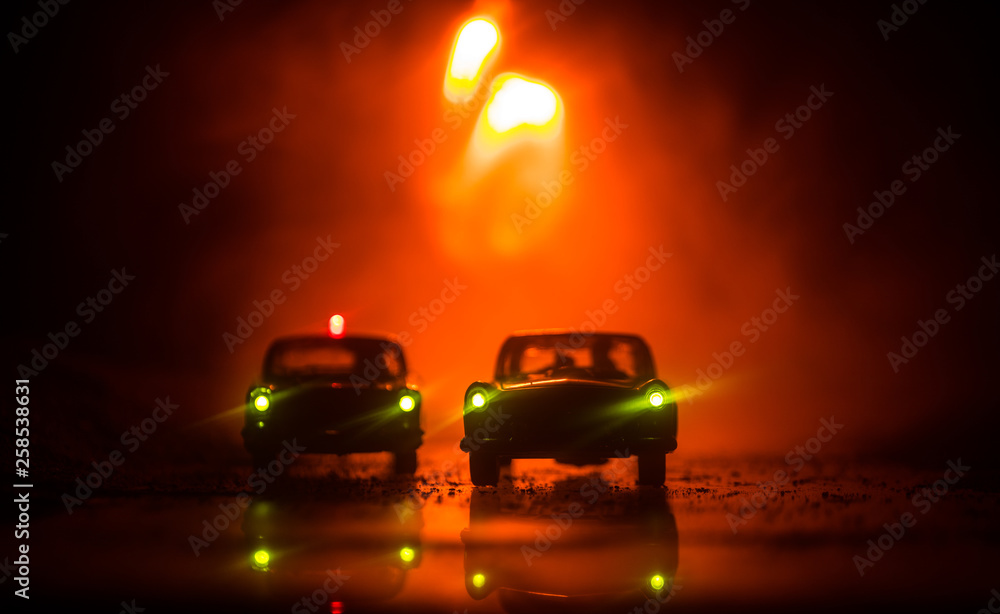 Police car chasing a car at night with fog background. 911 Emergency response police car speeding to scene of crime. Selective focus Police car chasing a car at night with fog background. 911 Emergency response police car speeding to scene of crime. Selective focus