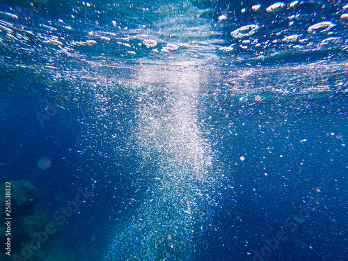 Air bubbles under the water rise up. Beautiful texture of sea and ocean water. Aerial blue background. Underwater photography. © Alwih