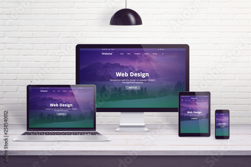 Responsive web site on multiple different display devices. Concept of web design, development work desk. photo