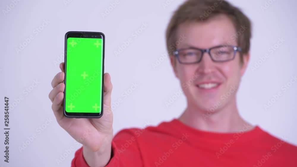 Face of happy young handsome man showing phone Face of happy young handsome man showing phone