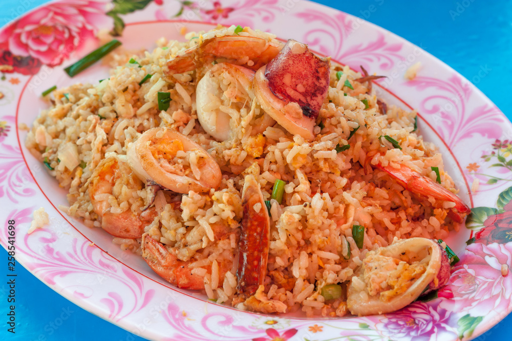 Seafood Fried rice with shrimp, squid, crab, vegetables on the dish thai style on blue table at restaurant. Thai style. Seafood Fried rice with shrimp, squid, crab, vegetables on the dish thai style on blue table at restaurant. Thai style.