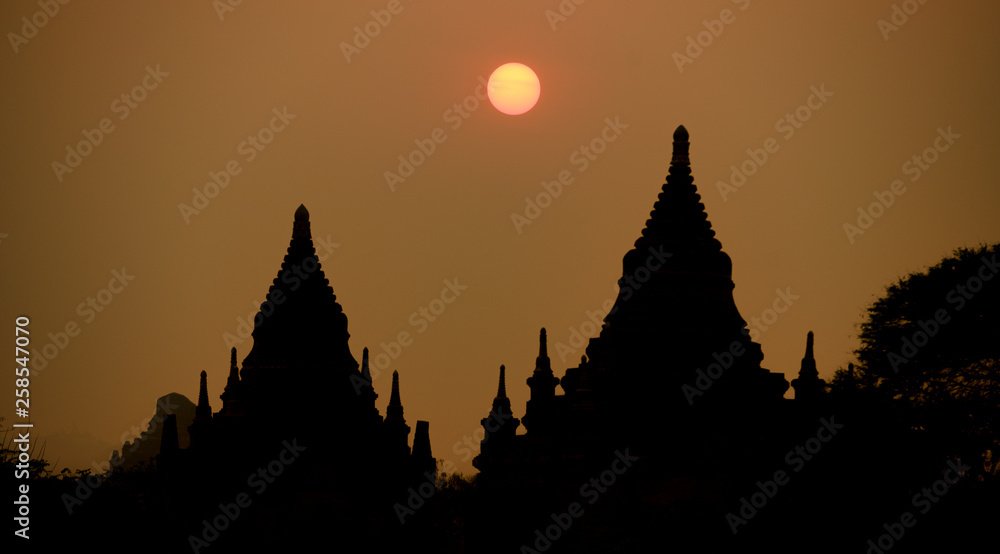 Stunning view of the silhouette of some of the many temples in Bagan (formerly Pagan) during sunset. The Bagan Archaeological Zone is a main attraction in Myanmar.