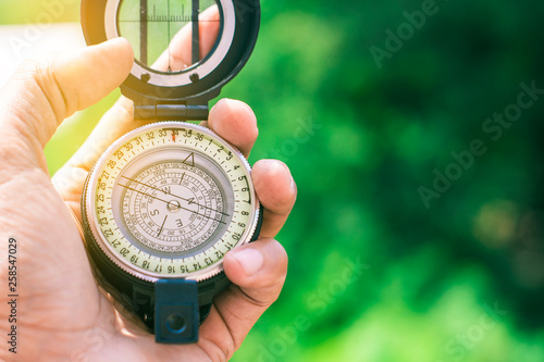 holding compass on blurred background. Using wallpaper or background travel or navigator image.