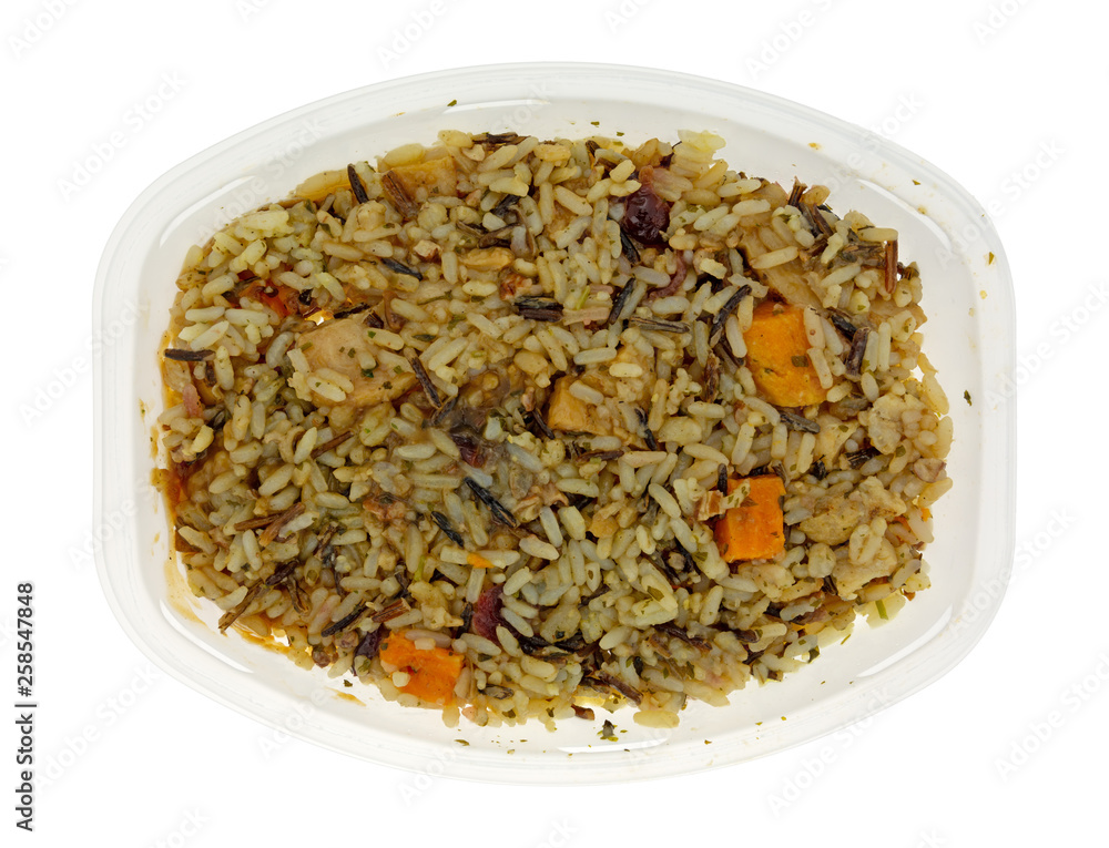 Chicken with pecans and wild rice TV dinner in a plastic tray isolated on a white background