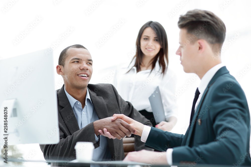 handshake of business partners sitting at a table Desk handshake of business partners sitting at a table Desk