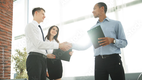 handshake of business partners standing in the office