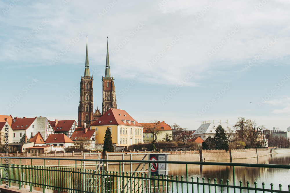 Cathedral of St. John the Baptist in Wroclaw, Poland and other buildings of a picturesque Tumski island. Colorful reflection in a water of Odra river. 