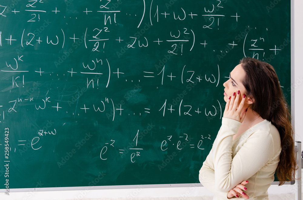 Young female math teacher in front of chalkboard Young female math teacher in front of chalkboard