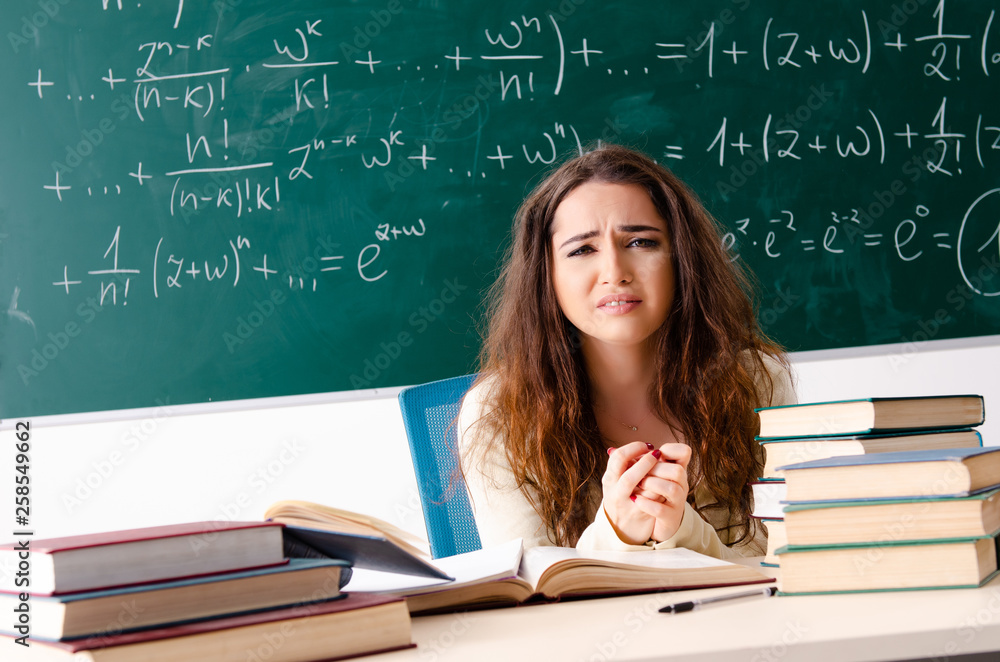 Young female math teacher in front of chalkboard Young female math teacher in front of chalkboard