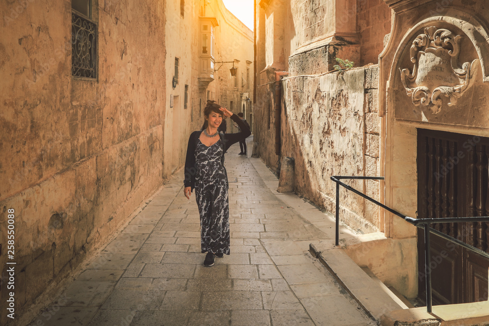 Beautiful asian woman tourist walking on the street in the old town of Rabat , malta