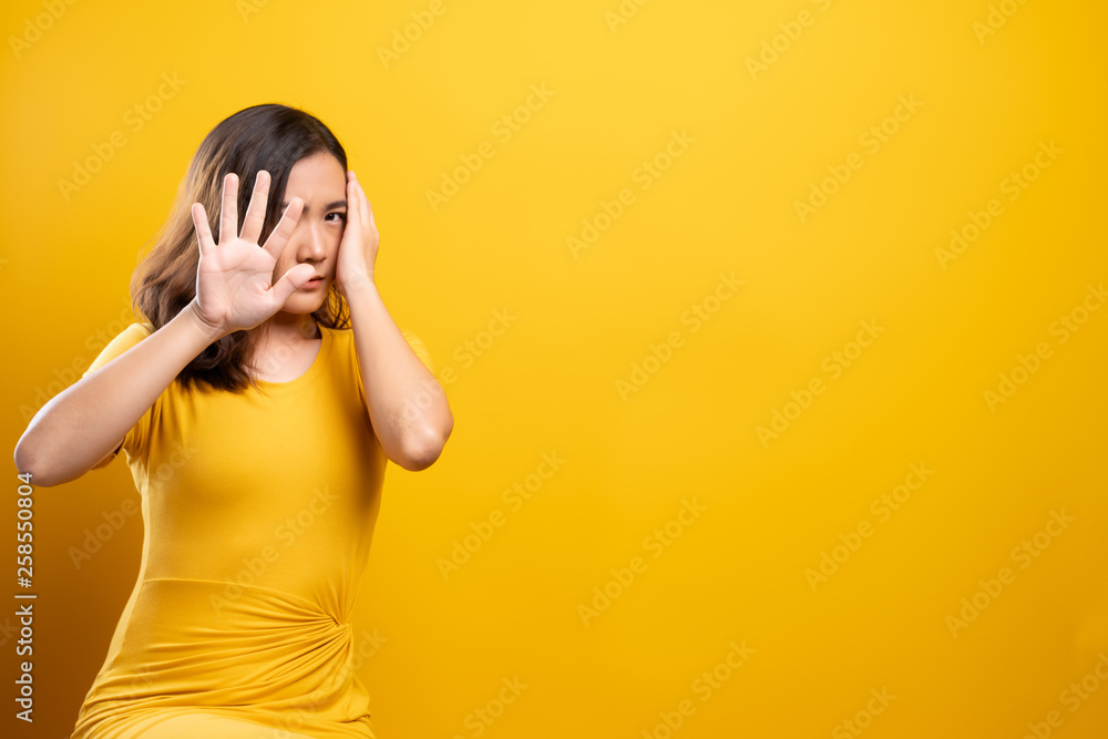 Woman feel scared standing isolated over yellow background Woman feel scared standing isolated over yellow background