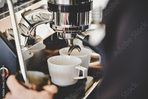 Barista arbeitet mit einer Kaffemaschine Cappuccino photo