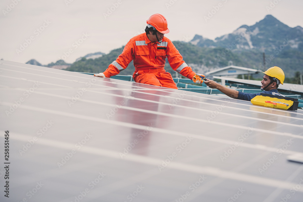engineer in solar power plant working on installing solar panel ; operation of solar power plant by smart operator engineer in solar power plant working on installing solar panel ; operation of solar power plant by smart operator