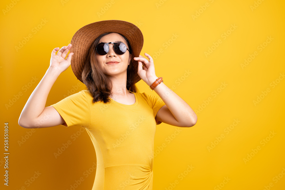 Portrait woman wearing sunglasses and hat isolated over yellow background Portrait woman wearing sunglasses and hat isolated over yellow background