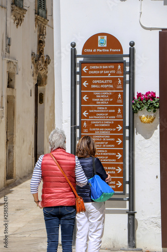 Wallpaper Mural Tourists observe the tourist signs in the streets of Martina Franca, Puglia, Italy Torontodigital.ca
