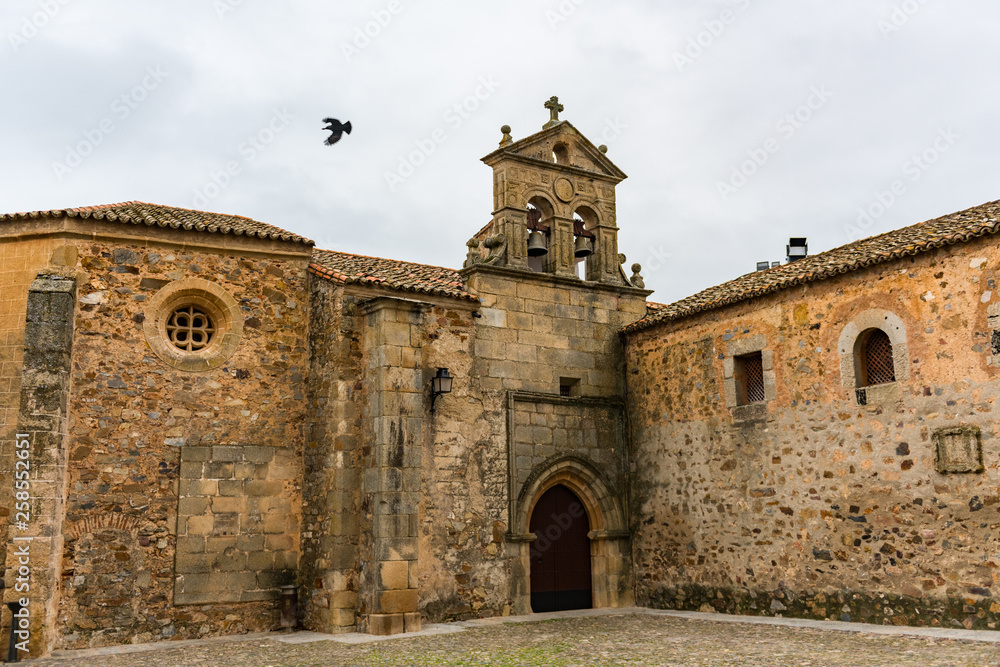 A crow flies over the door of the convent of San Pablo in the old town of Cacere.
