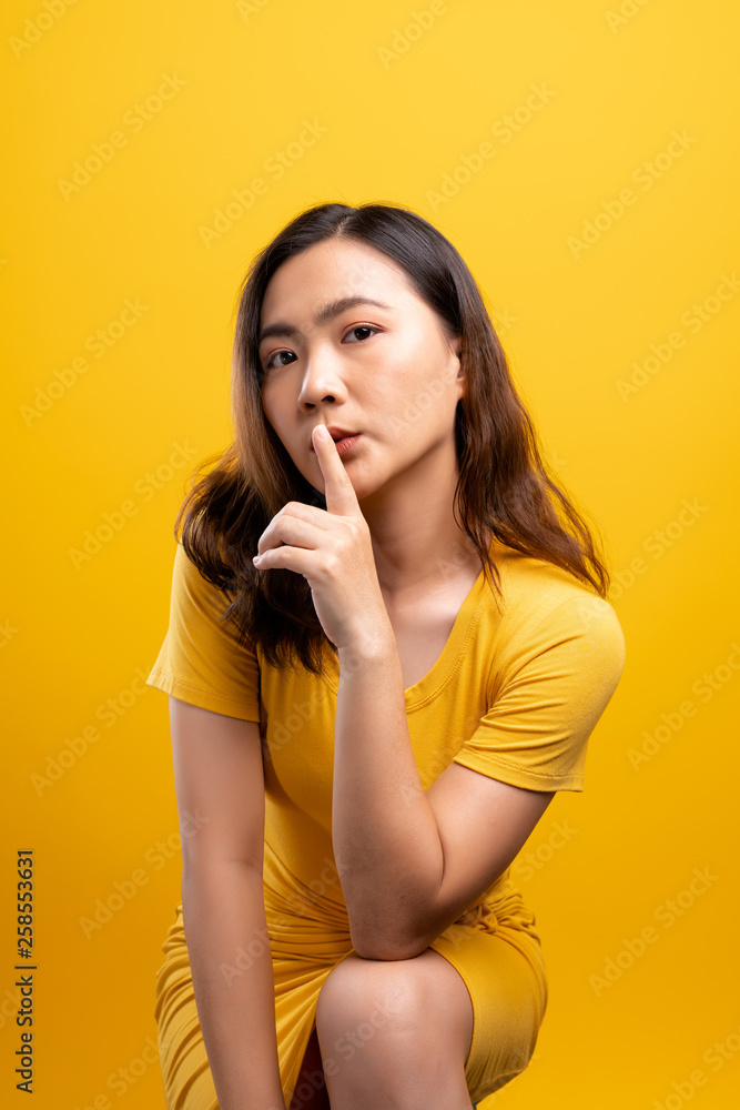 Fototapeta premium Woman show a quiet sign isolated over yellow background