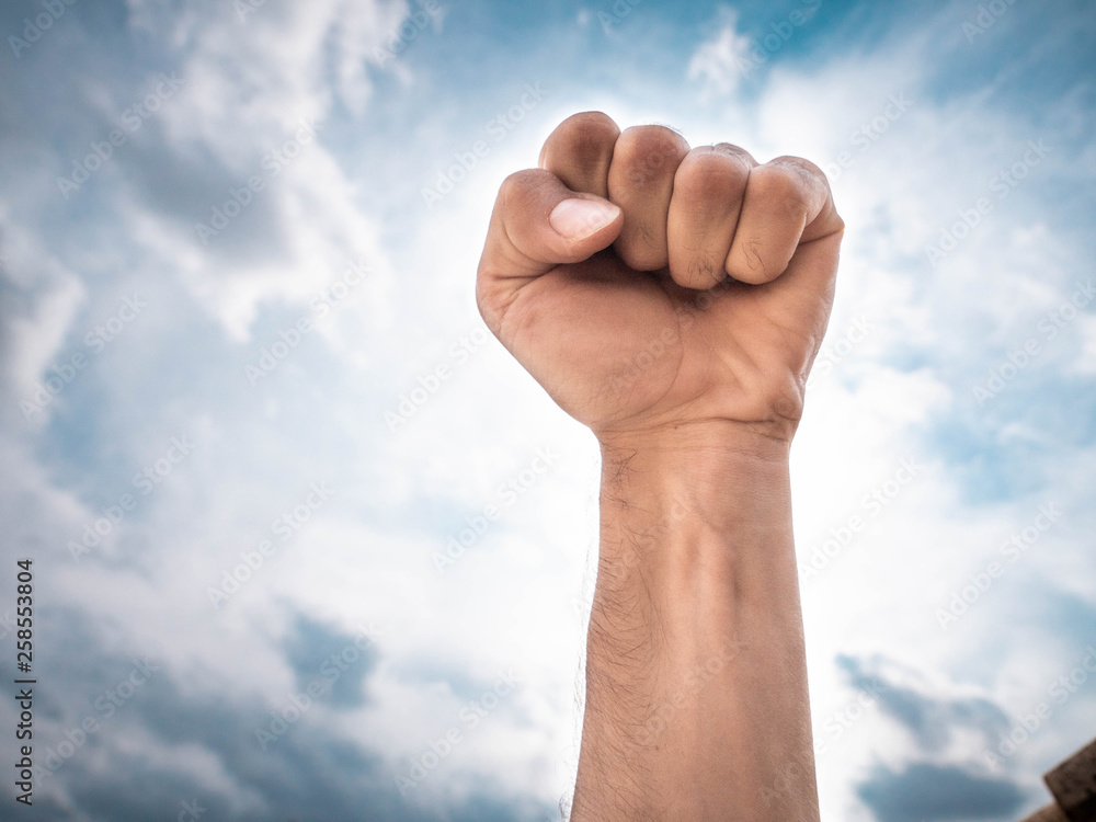 Rising fist over epic blue sky, anger, revolution, inspiration, motivation Rising fist over epic blue sky, anger, revolution, inspiration, motivation