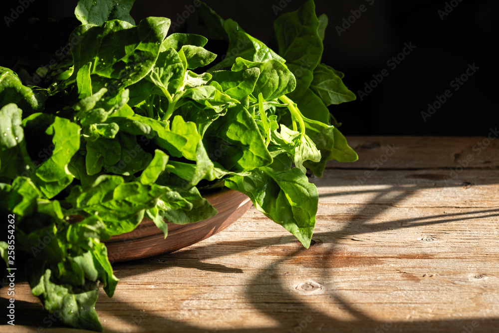 Fototapeta premium green fresh bunch of spinach in a beautiful cup on a wooden background