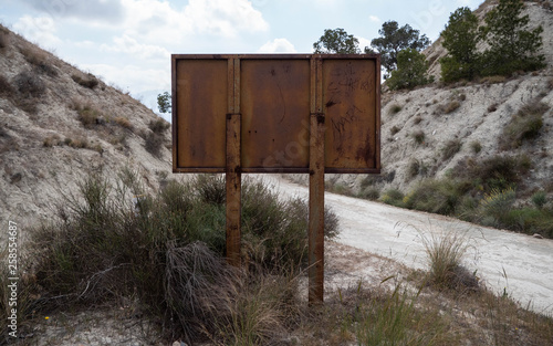 Rusty brown sign on a mountain dirt road