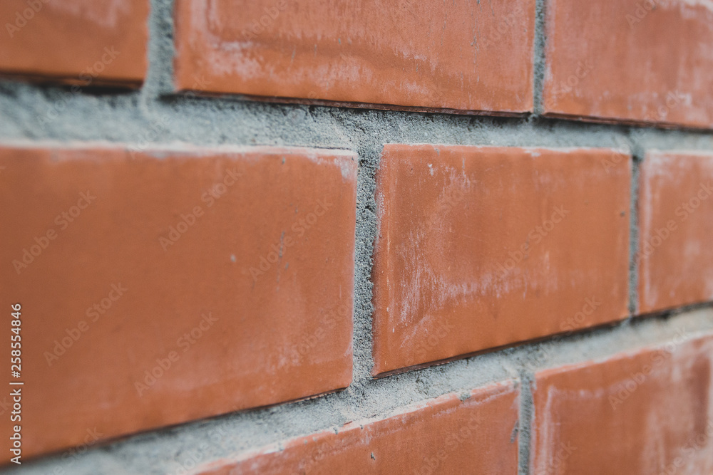 Obraz premium Closeup perspective view of a red brick wall, selective focus