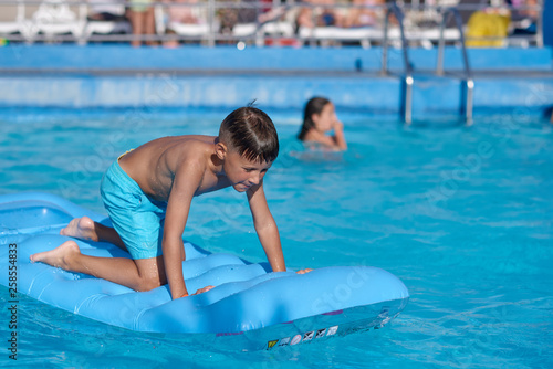 Smiling Caucasian boy having fun in swimming pool at resort on family vacation.