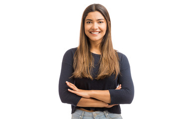Portrait of a pretty Hispanic woman with arms crossed in a studio